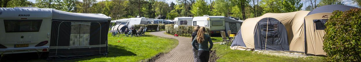 Vakantiegangers lopen over campingterrein.